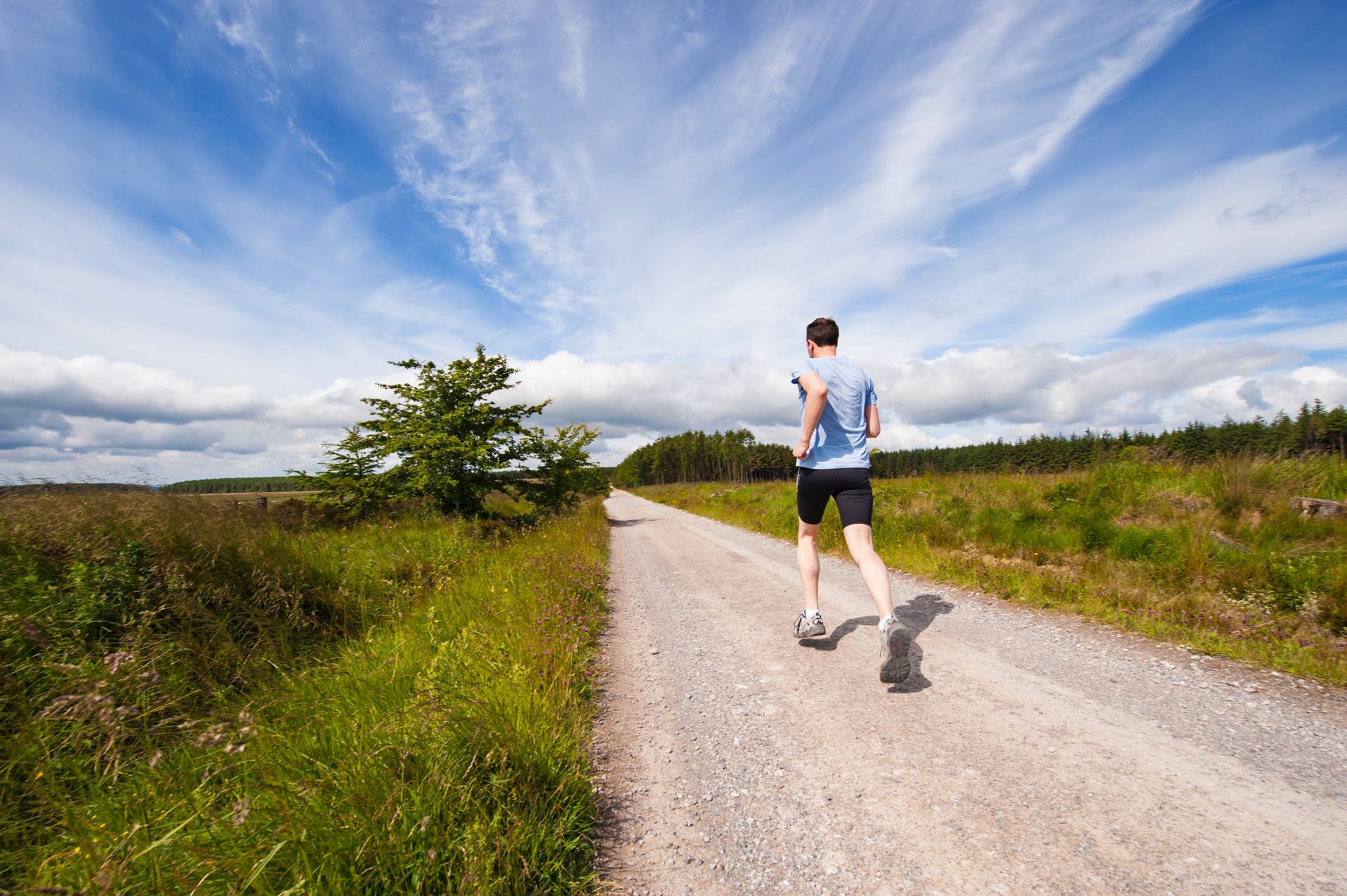 a man riding a bike down a dirt road